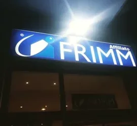 Insegna luminosa di un'agenzia affiliata Frimm di notte