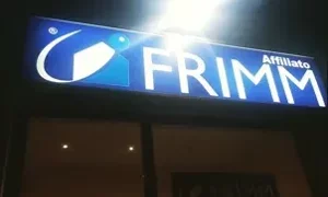 Insegna luminosa dell'affiliato Frimm di sera