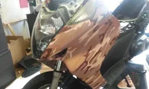 Moto con carena mimetica in un'officina