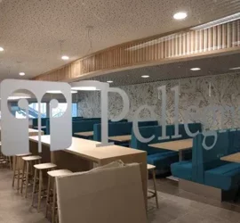 Interno di un moderno ristorante con tavoli e sedute azzurre