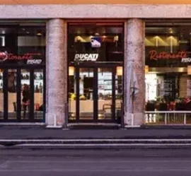 Facciata di un ristorante Ducati con ampie vetrate su strada urbana
