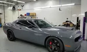 Auto sportiva grigia in un garage illuminato
