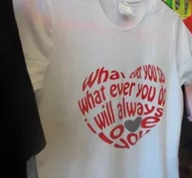 T-shirt bianca con stampa personalizzata a forma di cuore con testo rosso.