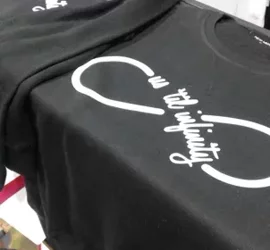Stampe personalizzate su magliette nere in esposizione.
