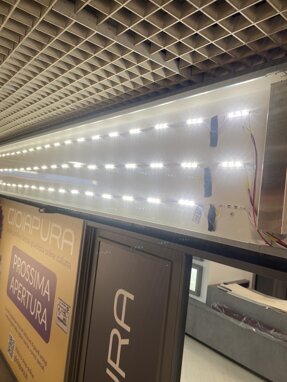 Installazione di luci LED per allestimento negozio con cartello di prossima apertura