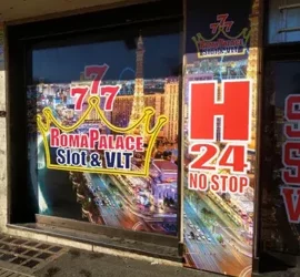 Vetrina di una sala slot con insegna Roma Palace Slot & VLT, aperta H24.