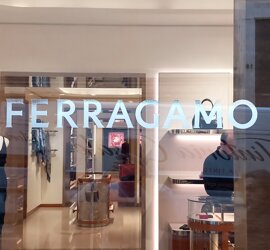Interno di un negozio di lusso con scritta Ferragamo sulla vetrina
