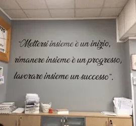 Citazione motivazionale su una parete di un ufficio con documenti e scaffali