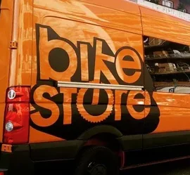 Furgone arancione con logo Bike Store, esempio di wrapping personalizzato Furgone arancione con logo Bike Store, esempio di wrapping personalizzato