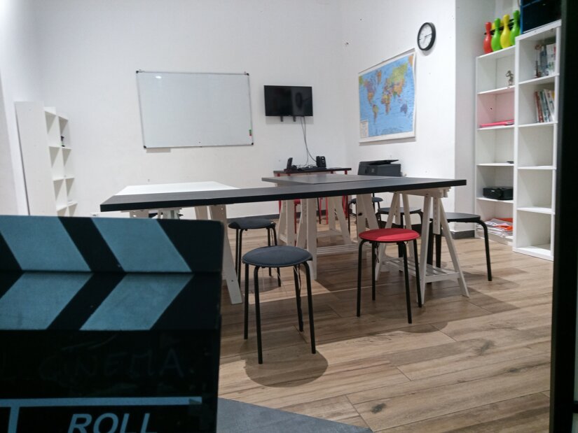 classroom with chairs, a map on the wall, and a clapperboard in the foreground classroom with chairs, a map on the wall, and a clapperboard in the foreground