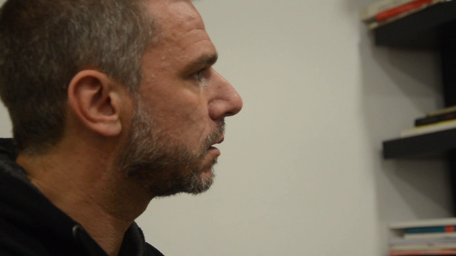 Profile of a man in a thoughtful expression, with books on a shelf in the background Profile of a man in a thoughtful expression, with books on a shelf in the background