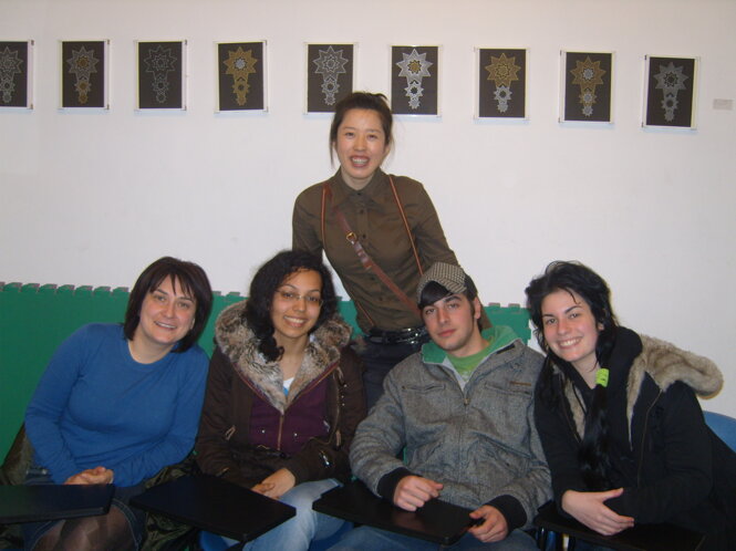 Group of diverse students in a classroom setting with art on the wall