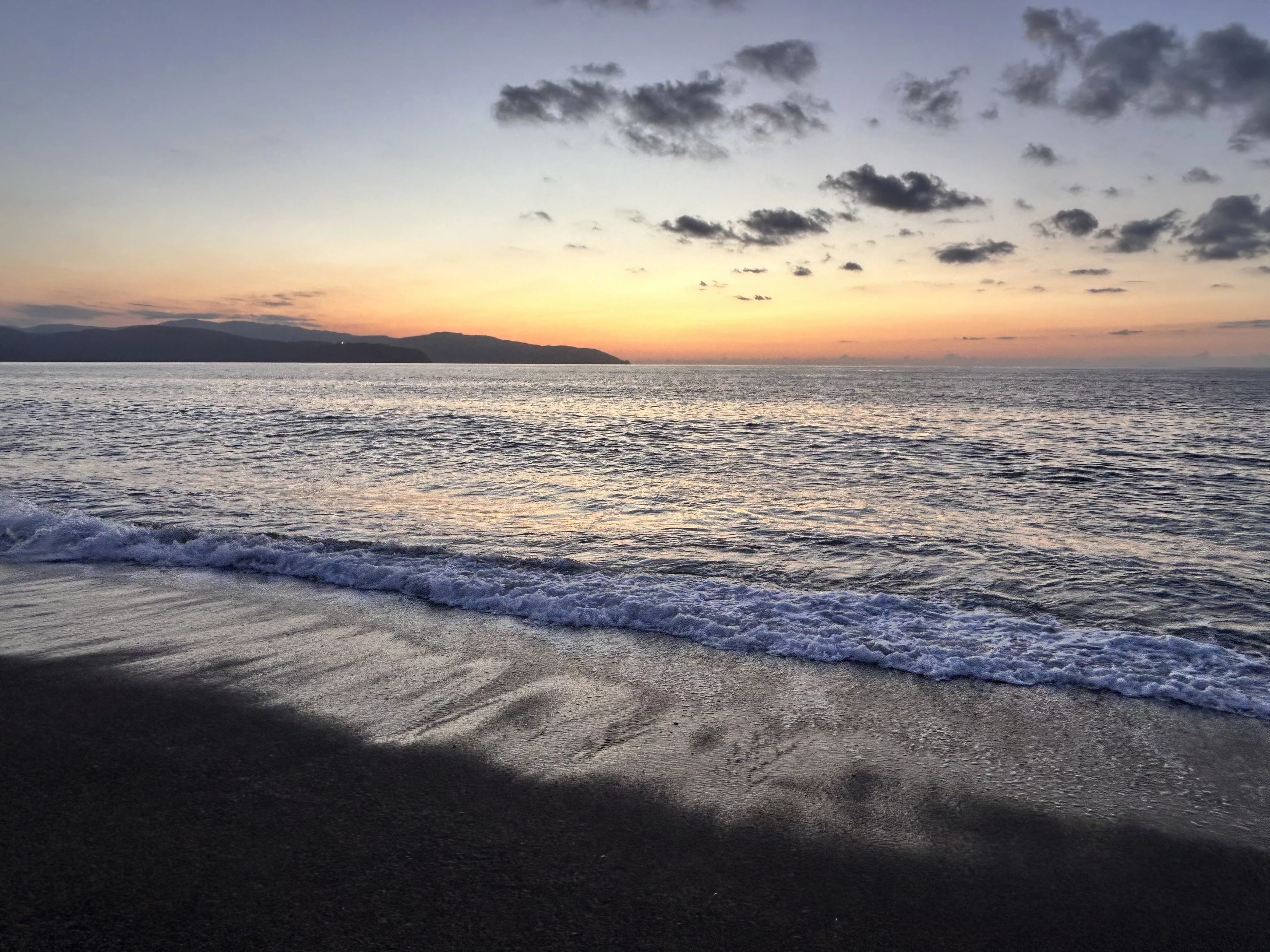 A beautiful sunset over the sea, with the sky painted in warm colors.