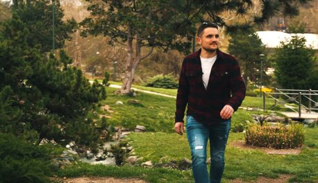 Man walking through a picturesque garden, surrounded by lush greenery