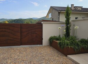 Cancello in metallo con design moderno, giardino privato con fiori e verde a sfioro su sfondo collinare. Cancello in metallo con design moderno, giardino privato con fiori e verde a sfioro su sfondo collinare.