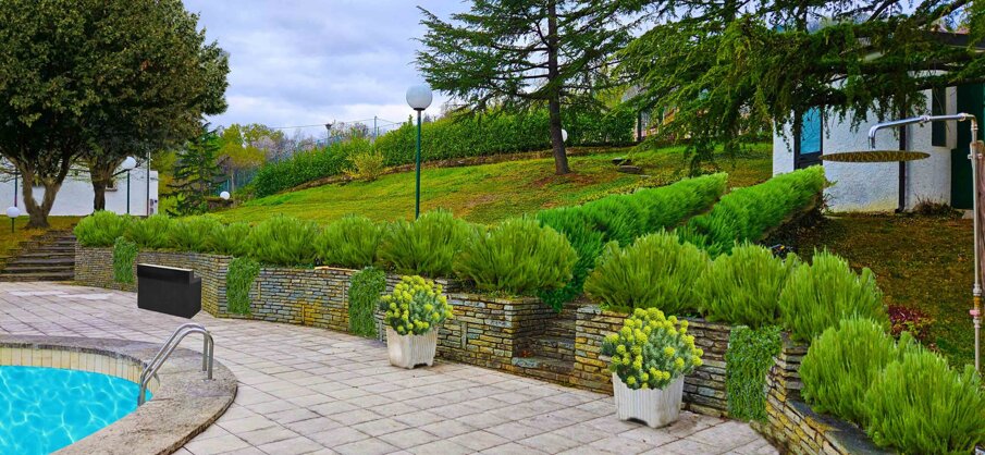 Giardino privato con piscina e cespugli verdi, progettazione verde con massi ciclopici Giardino privato con piscina e cespugli verdi, progettazione verde con massi ciclopici