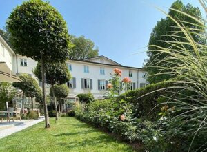 Giardino privato curato presso il Four Seasons Hotel Milano, con arbusti e fiori colorati.