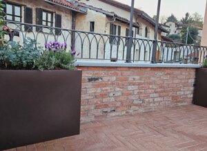 Terrazzo signorile a Pinerolo con fioriere e vista su edifici Terrazzo signorile a Pinerolo con fioriere e vista su edifici