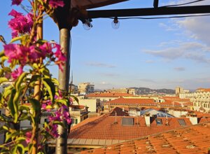 Vista di tetti rossi e fiori di bougainvillea su terrazzo tropicale in città
