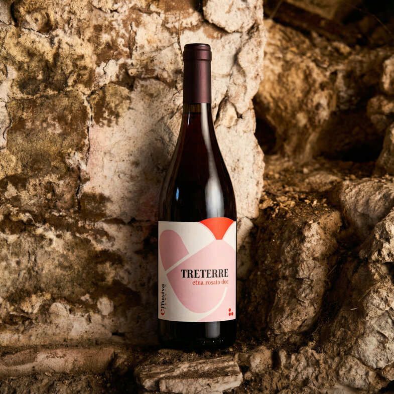 Bottle of Treterre Etna Rosato DOC wine against a rustic stone background