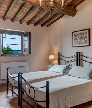 Comfortable double bedroom with private bathroom for large group accommodation in Volterra