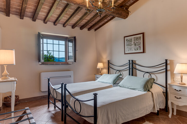 Comfortable twin-beds room with private bathroom for large group accommodation in Volterra