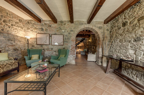 Spacious stone wall living room for large groups inside exclusive Tuscan farmhouse