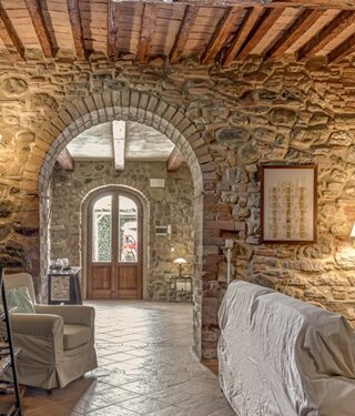 Spacious stone wall living room for large groups inside exclusive Tuscan farmhouse