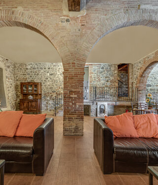 Spacious stone wall living room for large groups inside exclusive Tuscan farmhouse