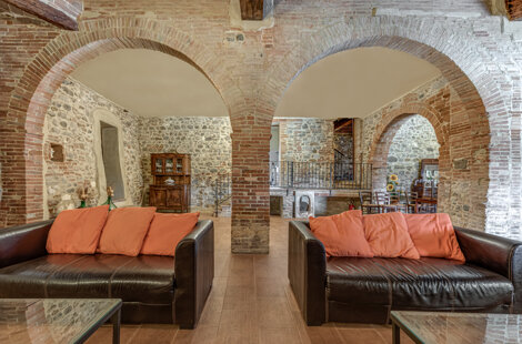 Spacious stone wall living room for large groups inside exclusive Tuscan farmhouse