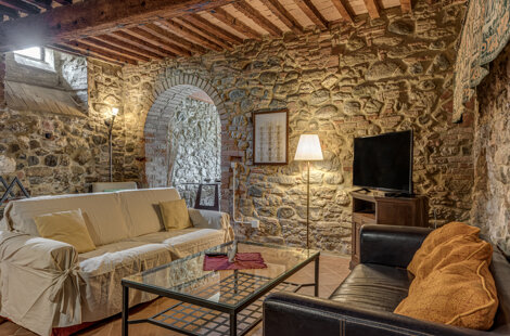 Spacious stone wall living room for large groups inside exclusive Tuscan farmhouse