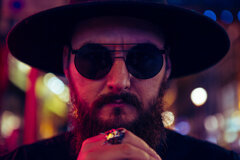 MURDAH SRVC lead artist close-up with moody red and blue lighting - cyberpunk aesthetic