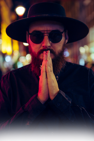 Murdah with sunglasses and hands joined in prayer pose under red light murdah srvc photo