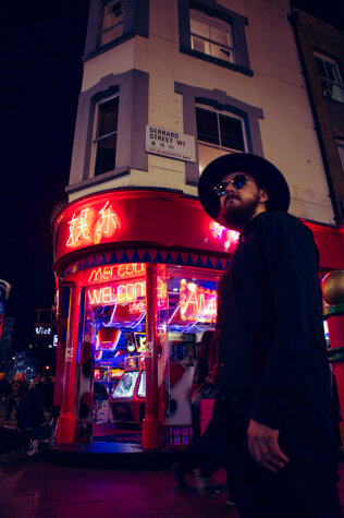 MURDAH SRVC artist in front of a neon arcade in London - audiovisual project inspired by Japanese pop culture