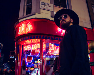 MURDAH SRVC artist in front of a neon arcade in London - audiovisual project inspired by Japanese pop culture