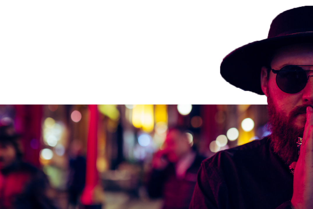 Murdah with hat and sunglasses in a neon-lit street at night murdah srvc photo