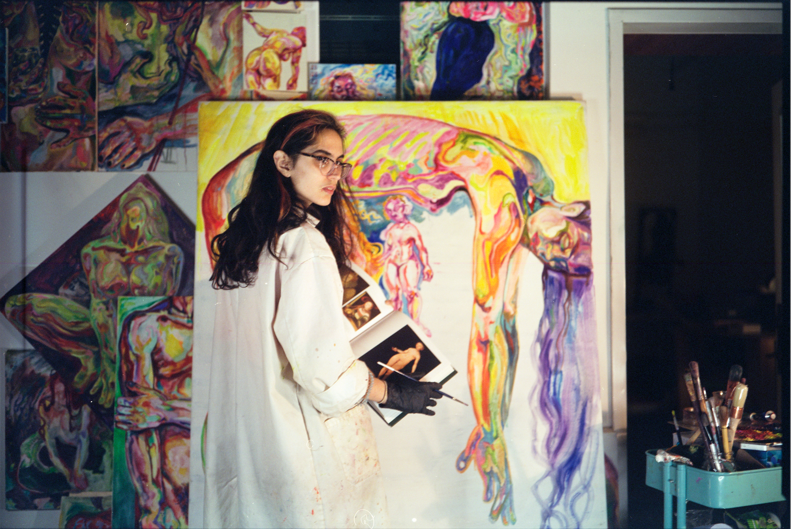 eyJlbiI6IlZhbGVudGluZSBBbG1hIGluIGhlciBNb250culhbCBzdHVkaW8gd2l0aCBjb2xvcmZ1bCBwYWludGluZ3MsIGNvbnRlbXBvcmFyeSBhcnRpc3Qgd29ya2luZyBvbiBjYW52YXMuIn0=