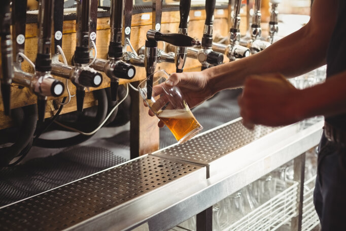 mid-section-bar-tender-filling-beer-from-bar-pump.jpeg