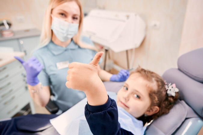 female-dentist-cute-little-girl-giving-thumbs-up.jpeg