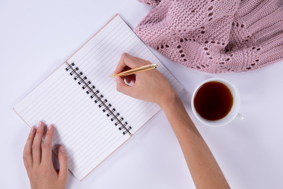woman-writing-his-notebook-light-pink-background.jpeg