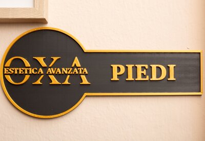 insegna con la scritta Oxa Estetica Avanzata, Piedi