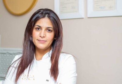 estetista Elena Hoxha con dietro attestati di abilitazione della Regione Piemonte