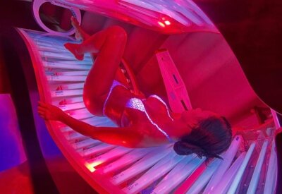 eagazza in costume nella lampada abbronzante del solarium