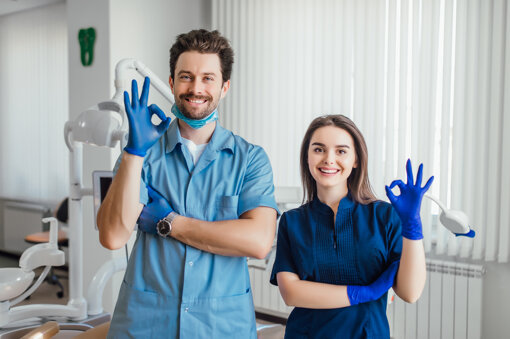 photo-smiling-dentist-standing-with-arms-crossed-with-her-colleague-showing-okay-sign.jpeg