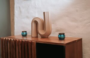 Modernes Holz-Sideboard mit dekorativen Vasen im Ruheraum von Harmony Wellness, einem Private Spa in Vitznau am Vierwaldstättersee.
