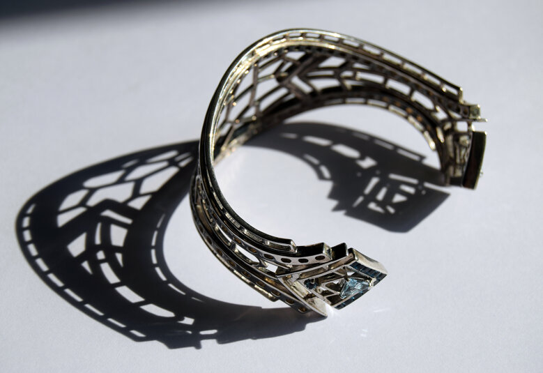 Gioiello d'artista *Bracciale Anima Urbana* in bronzo rodiato con topazi azzurri. Ispirato alle forme degli isolati urbani . Urban Slivers Design