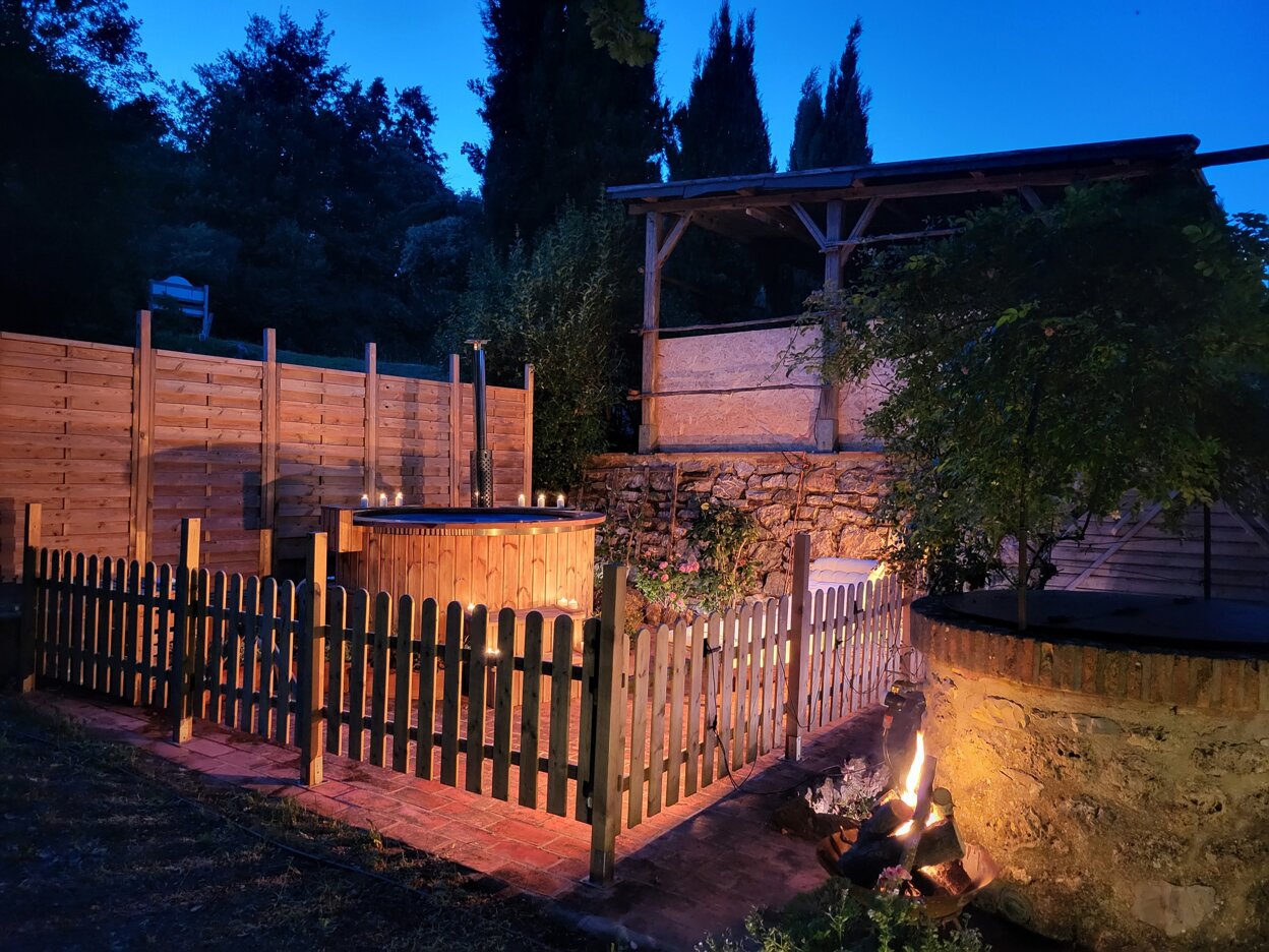 farmhouse with natural fire-heated hot tub in Tuscany, sustainable countryside relaxation experience, wooden tub with spring water Tuscany, starlit bathing in Maremma, natural and silent Tuscan wellness retreat