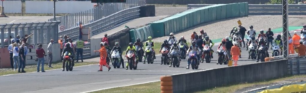 Piloti pronti alla partenza di una gara motociclistica su pista Piloti pronti alla partenza di una gara motociclistica su pista