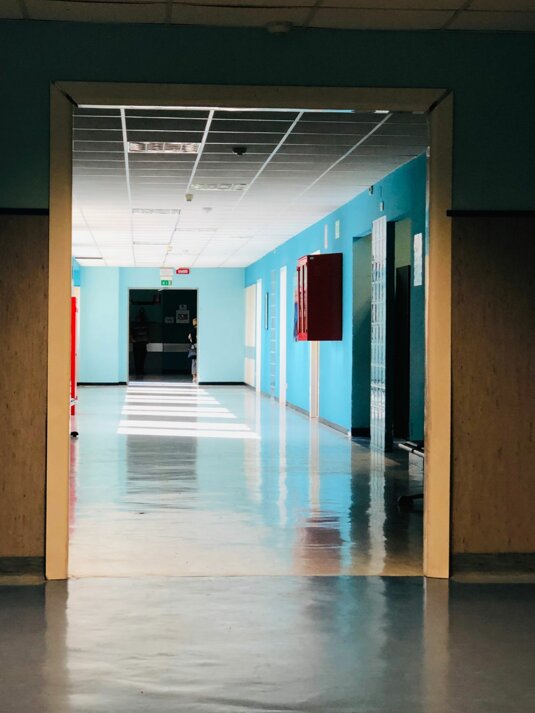 Corridoio di un ospedale con pareti blu e soffitto a pannelli. Corridoio di un ospedale con pareti blu e soffitto a pannelli.