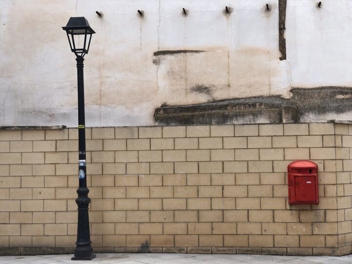 Lampione e cassetta delle lettere su muro in mattoni